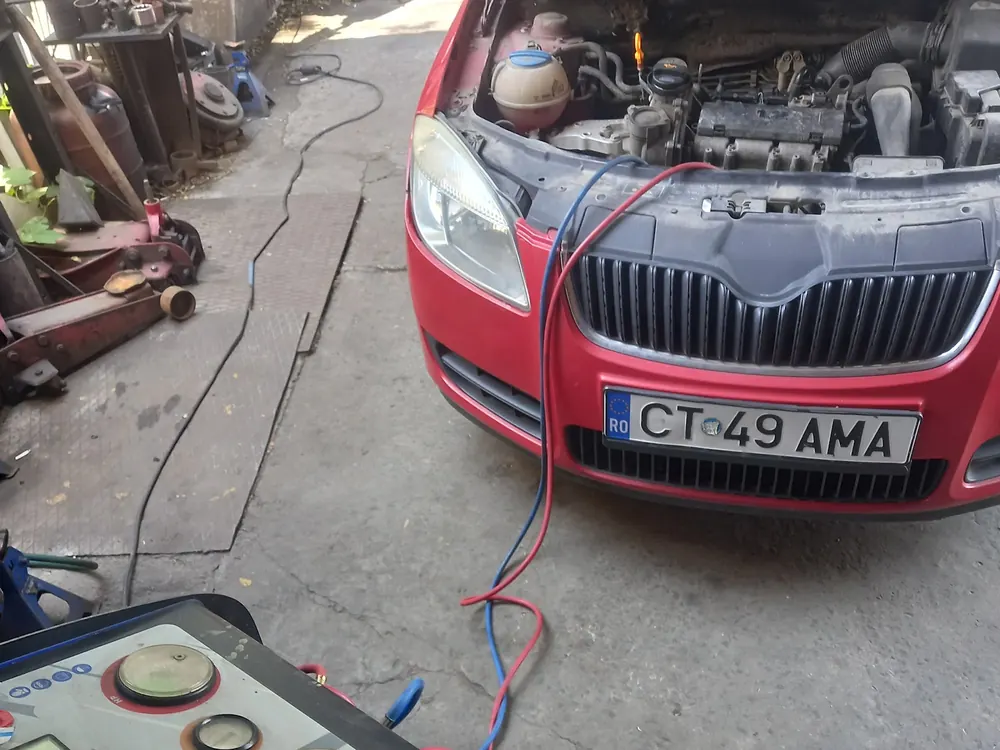Echipament de service auto conectat la un autoturism cu motorul deschis, în atelier
